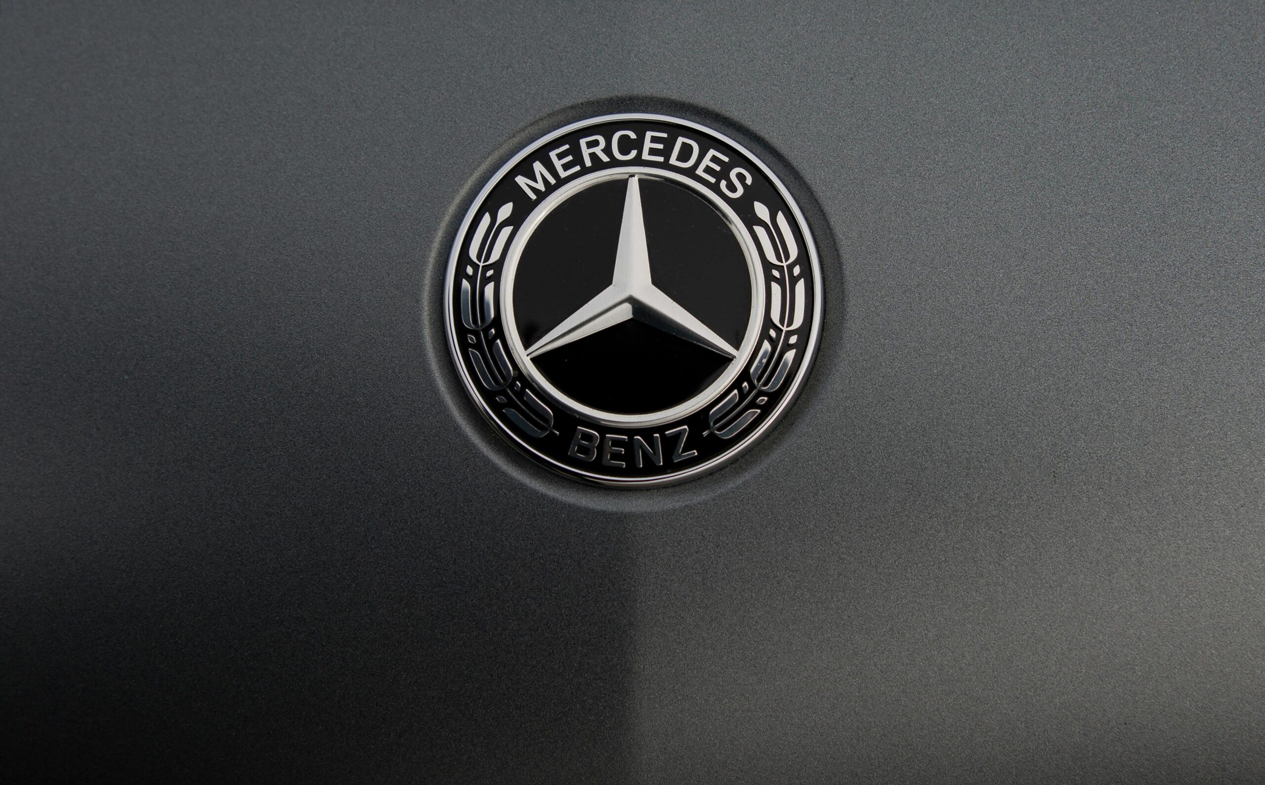 Closeup badge of world famous modern expensive luxury car on dark grey background